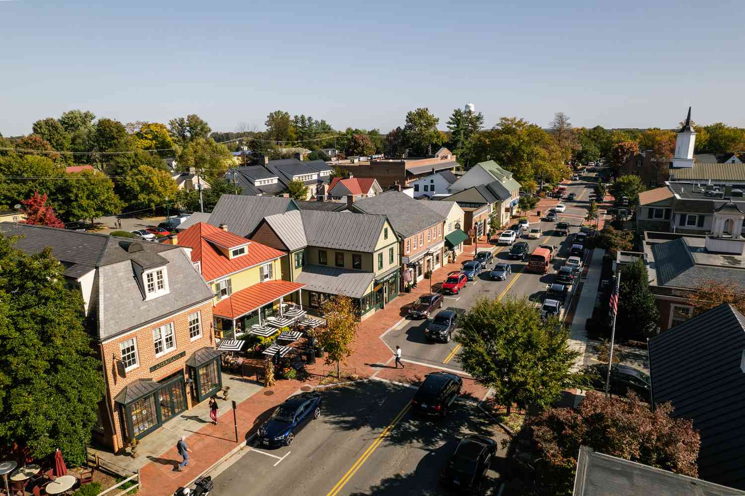 Aerial view of downtown Middleburg with brick sidewalks, shops, sidewalk dining, and traffic along the main street